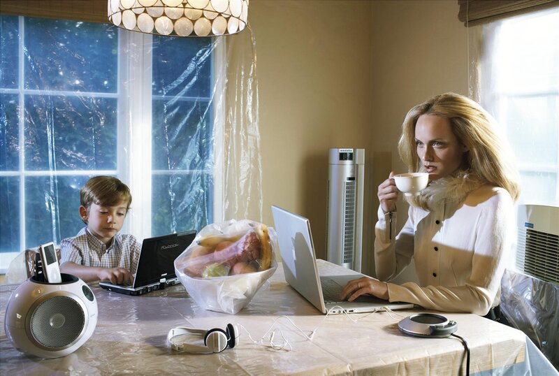 Mother and son using laptops at table