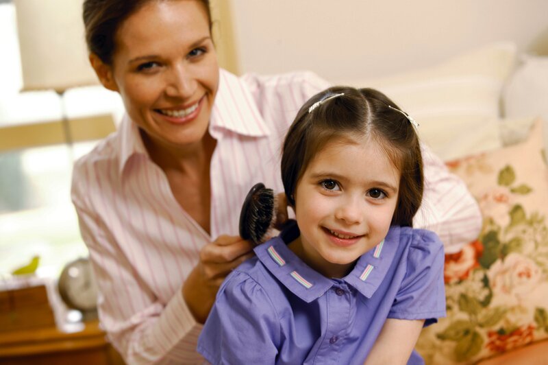 Mother brushing daughter's hair