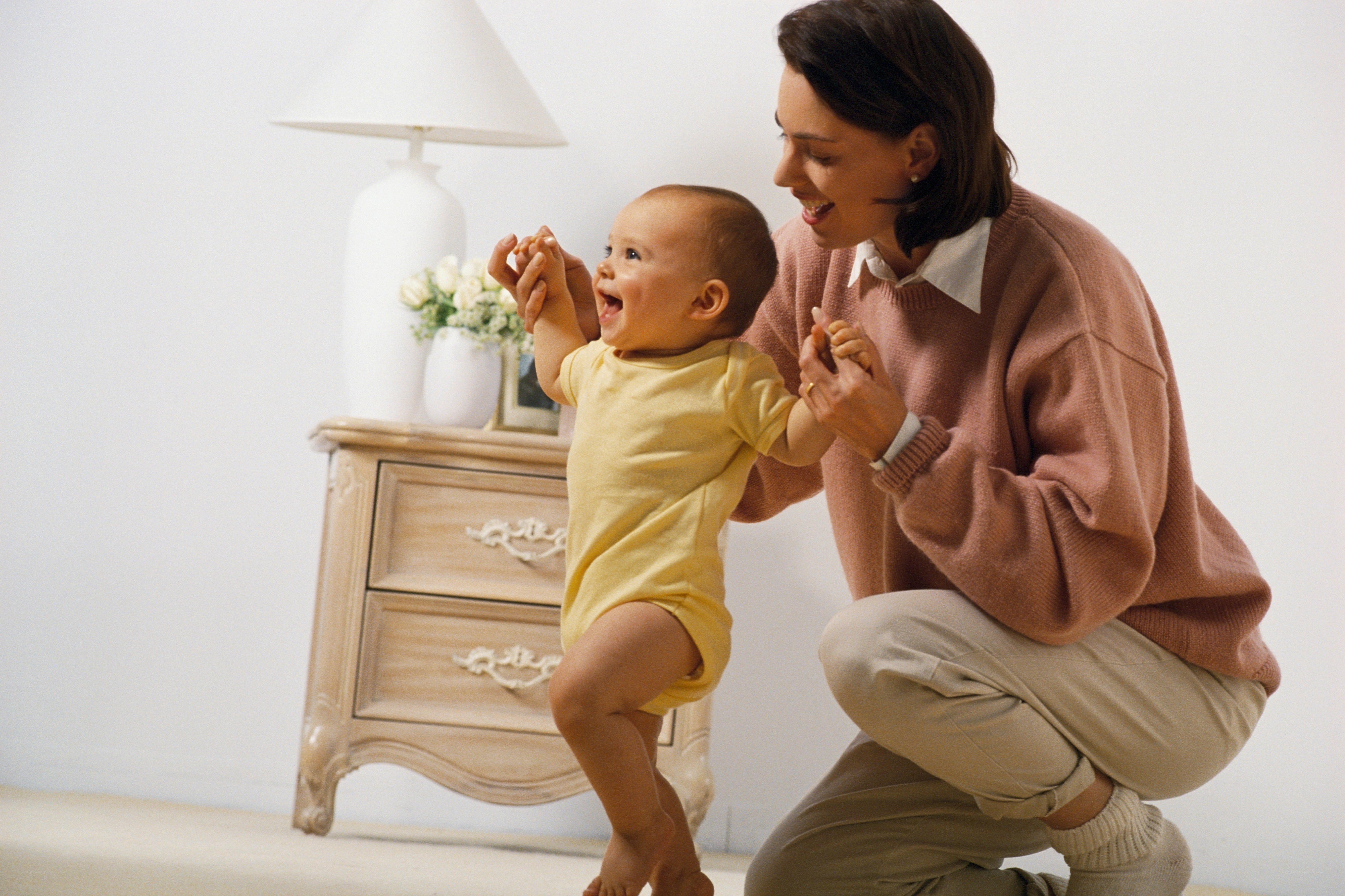 Mother helping baby walk