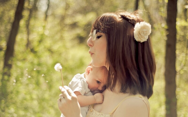 Mother holding baby in forest