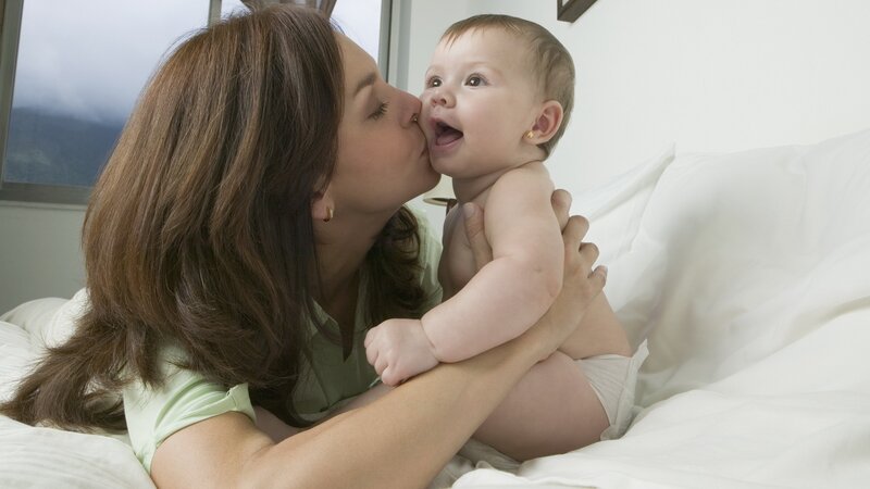 mother kissing baby on cheek