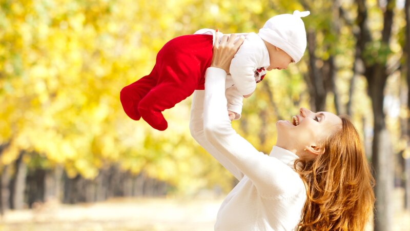 Mother playing with baby outdoors