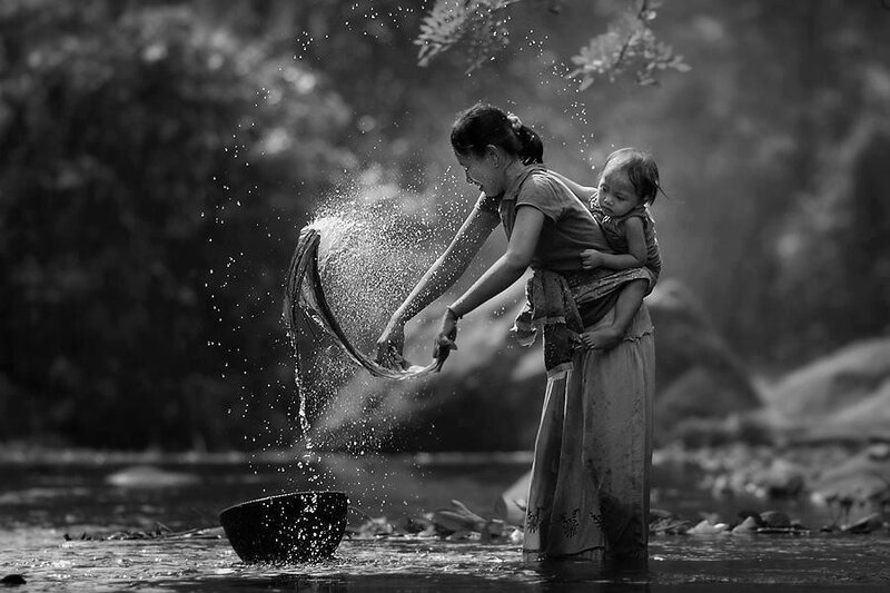 Mother washing clothes with child