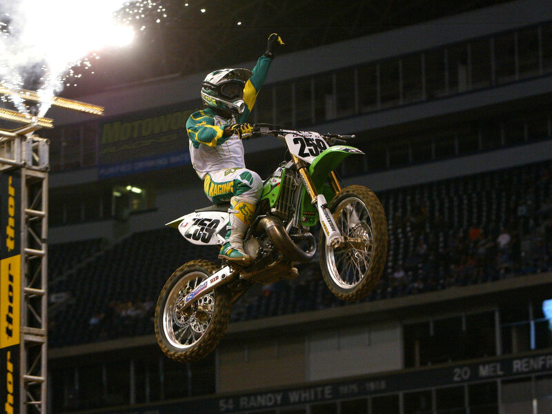 Motocross rider celebrating mid-air