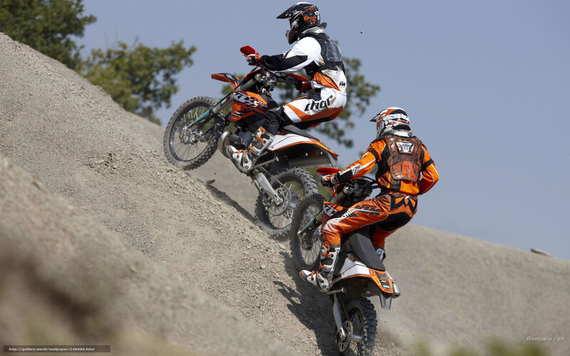 Motocross riders on a dirt hill