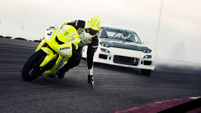 Motorcycle and car drifting on track