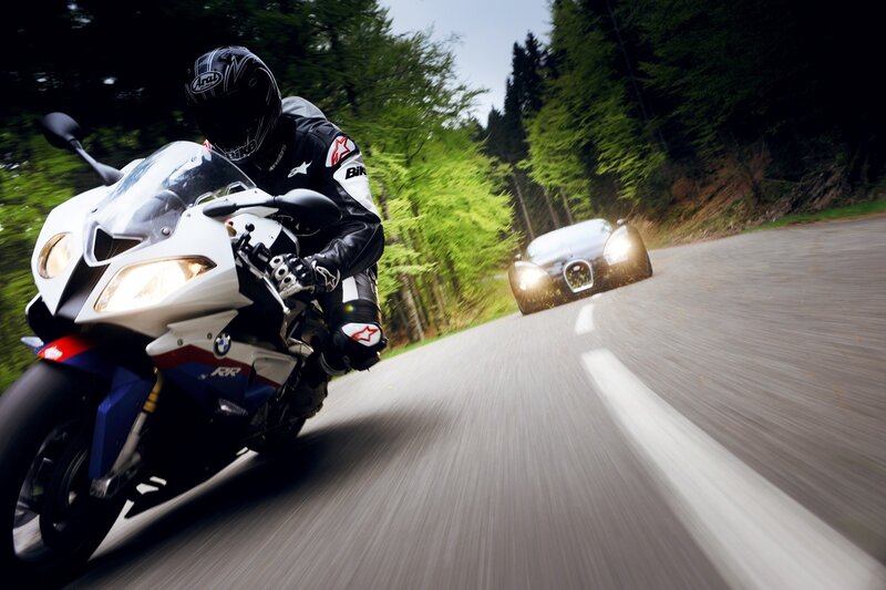 Motorcycle and car on forest road