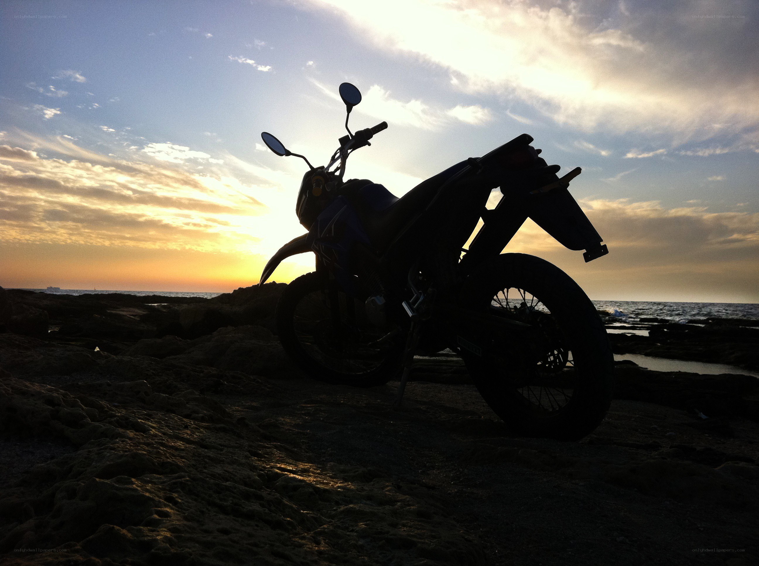 Motorcycle on the beach at sunset