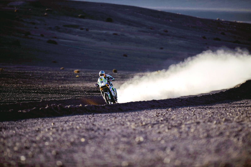 Motorcycle racer on dusty terrain