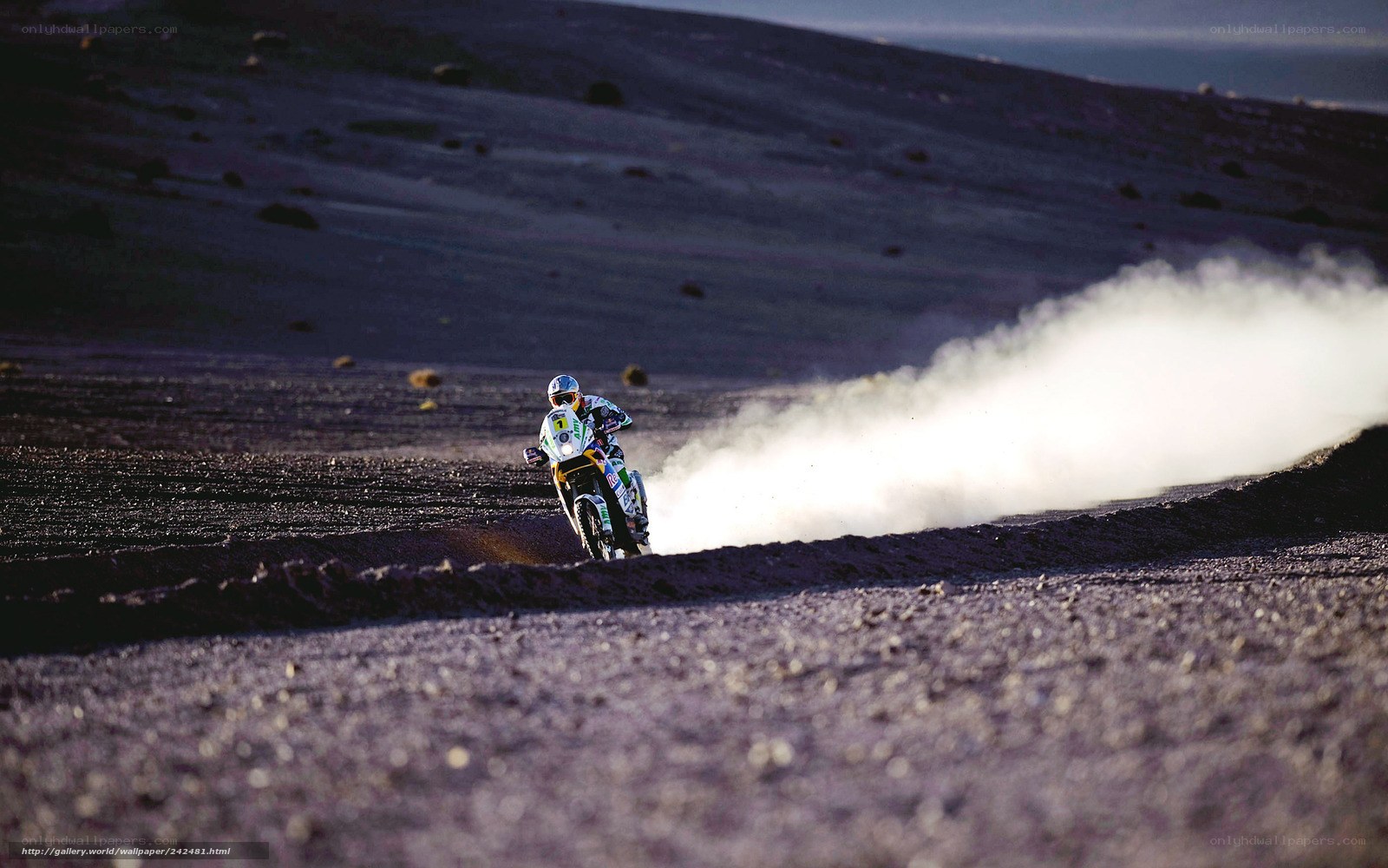 Motorcycle racer on dusty terrain
