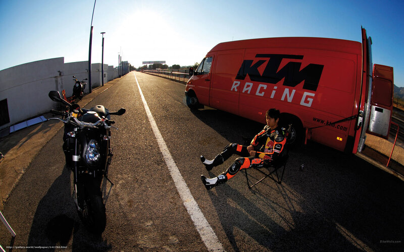 Motorcycle racer resting on track