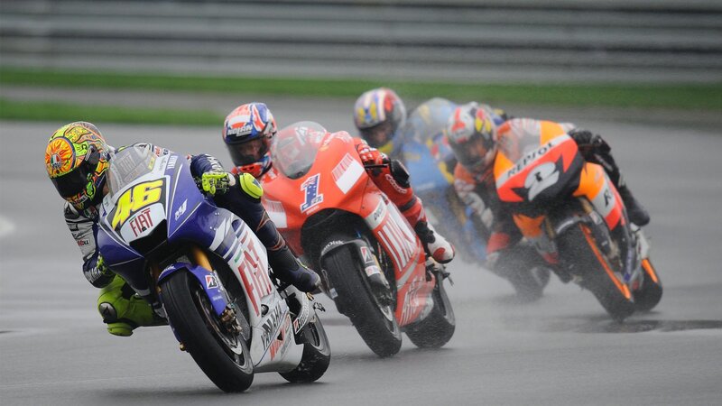 Motorcycle racers on a wet track