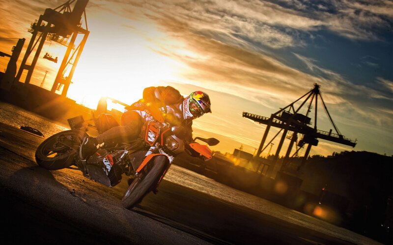 Motorcycle rider at sunset in port