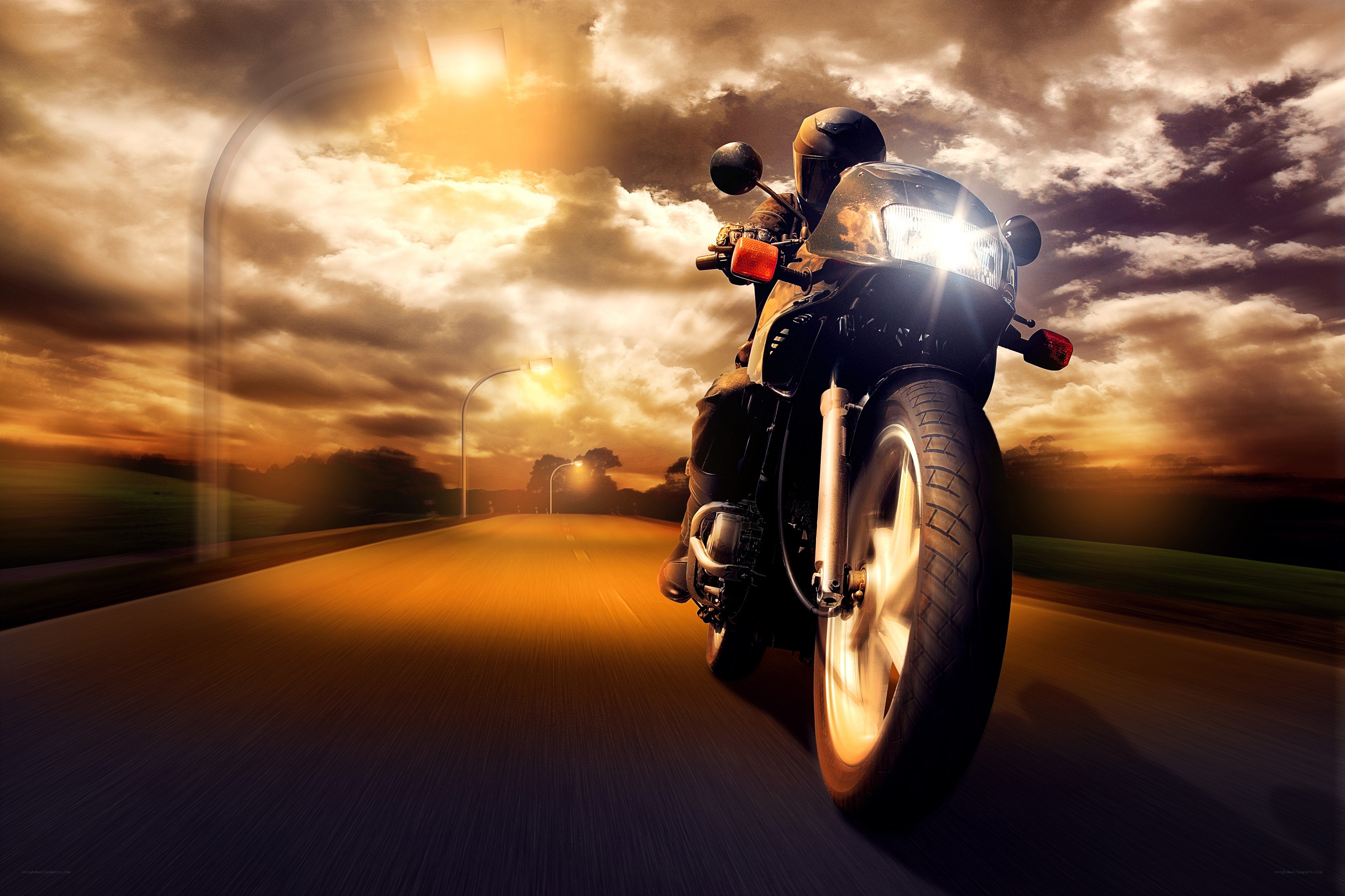Motorcycle rider on a road at sunset