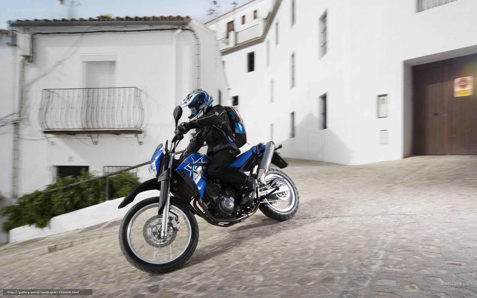motorcycle rider on cobblestone street
