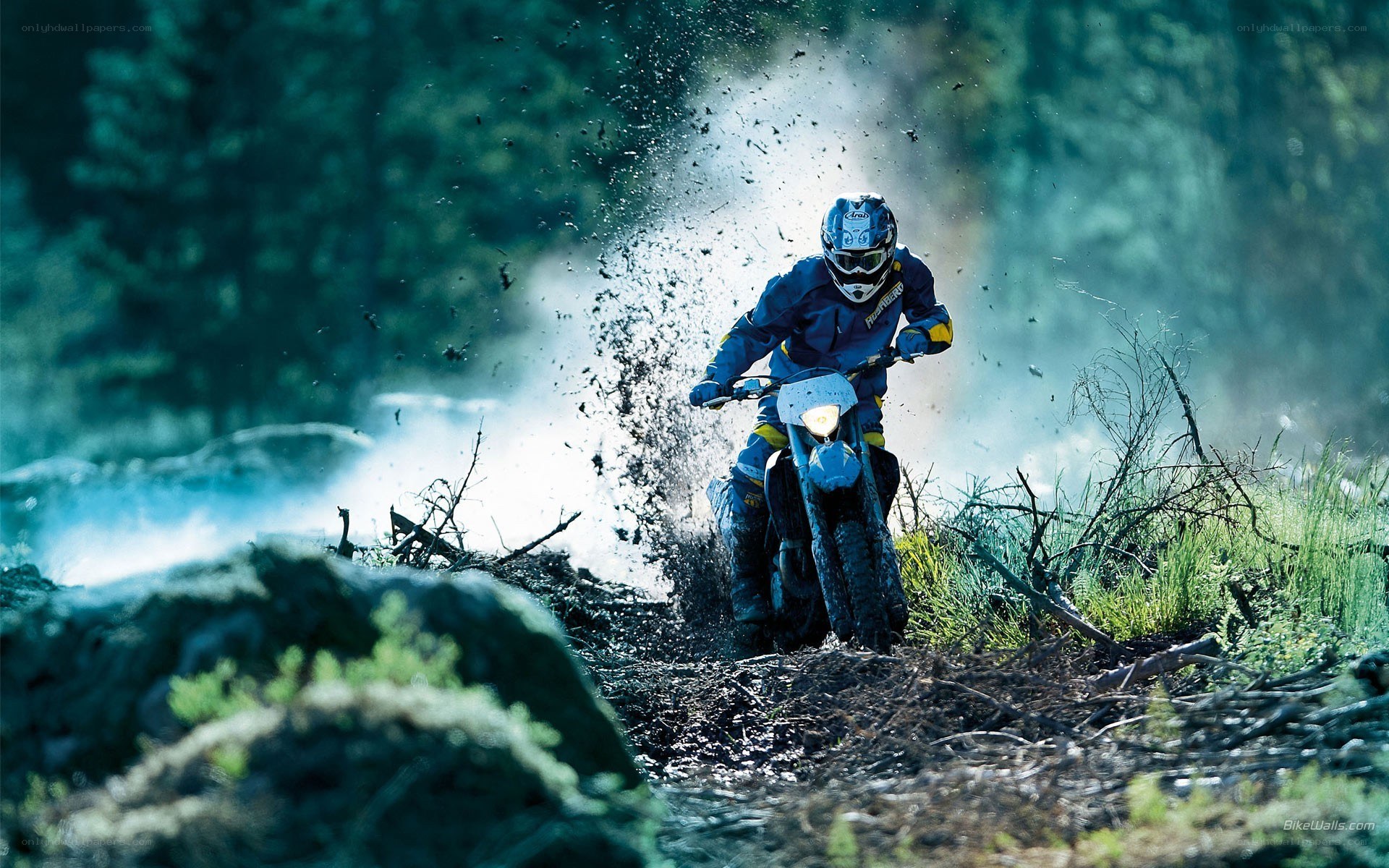 Motorcycle rider on muddy trail