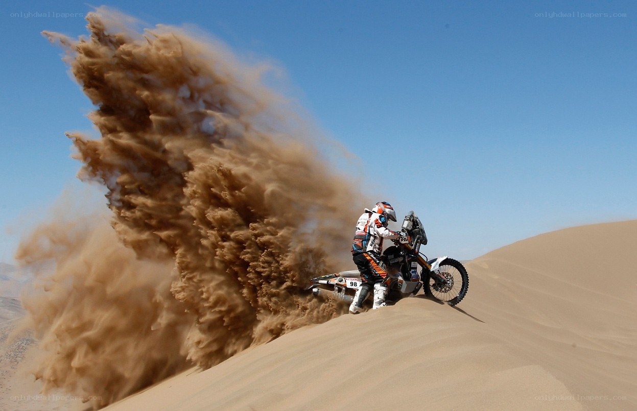 Motorcycle rider on sand dune