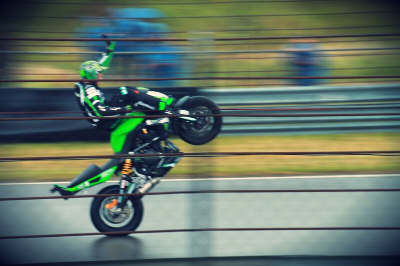 Motorcycle Rider Performing Wheelie — Green, Dynamic, Photograph