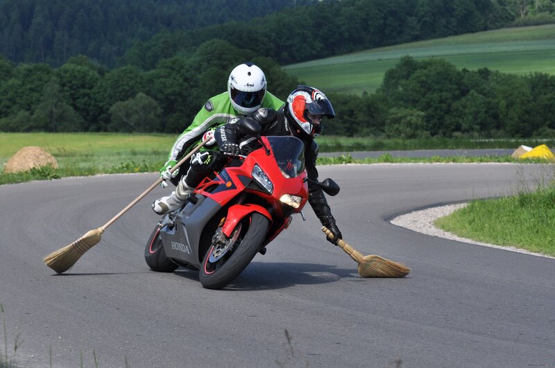 Motorcycle riders with brooms