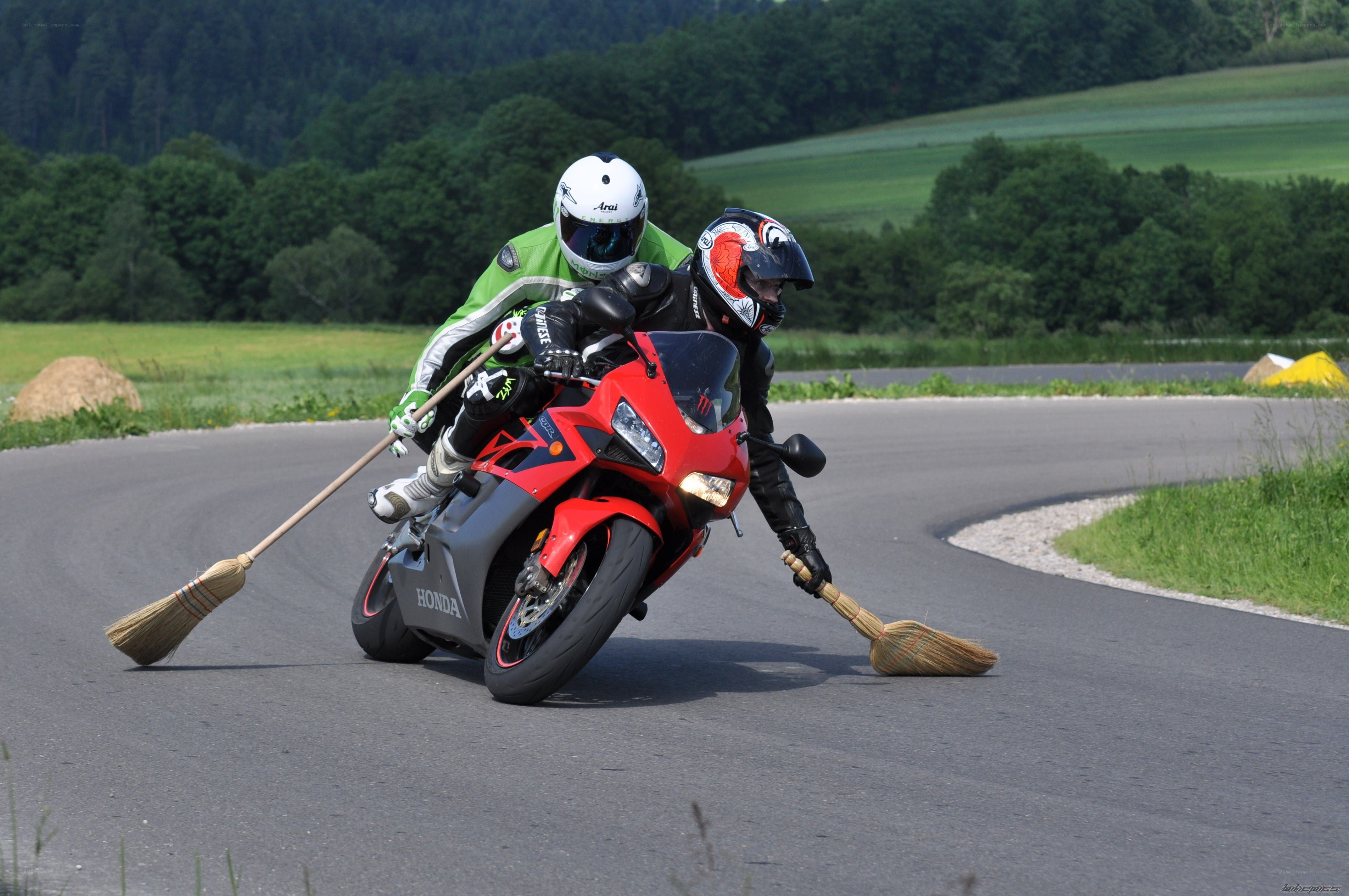 Motorcycle riders with brooms