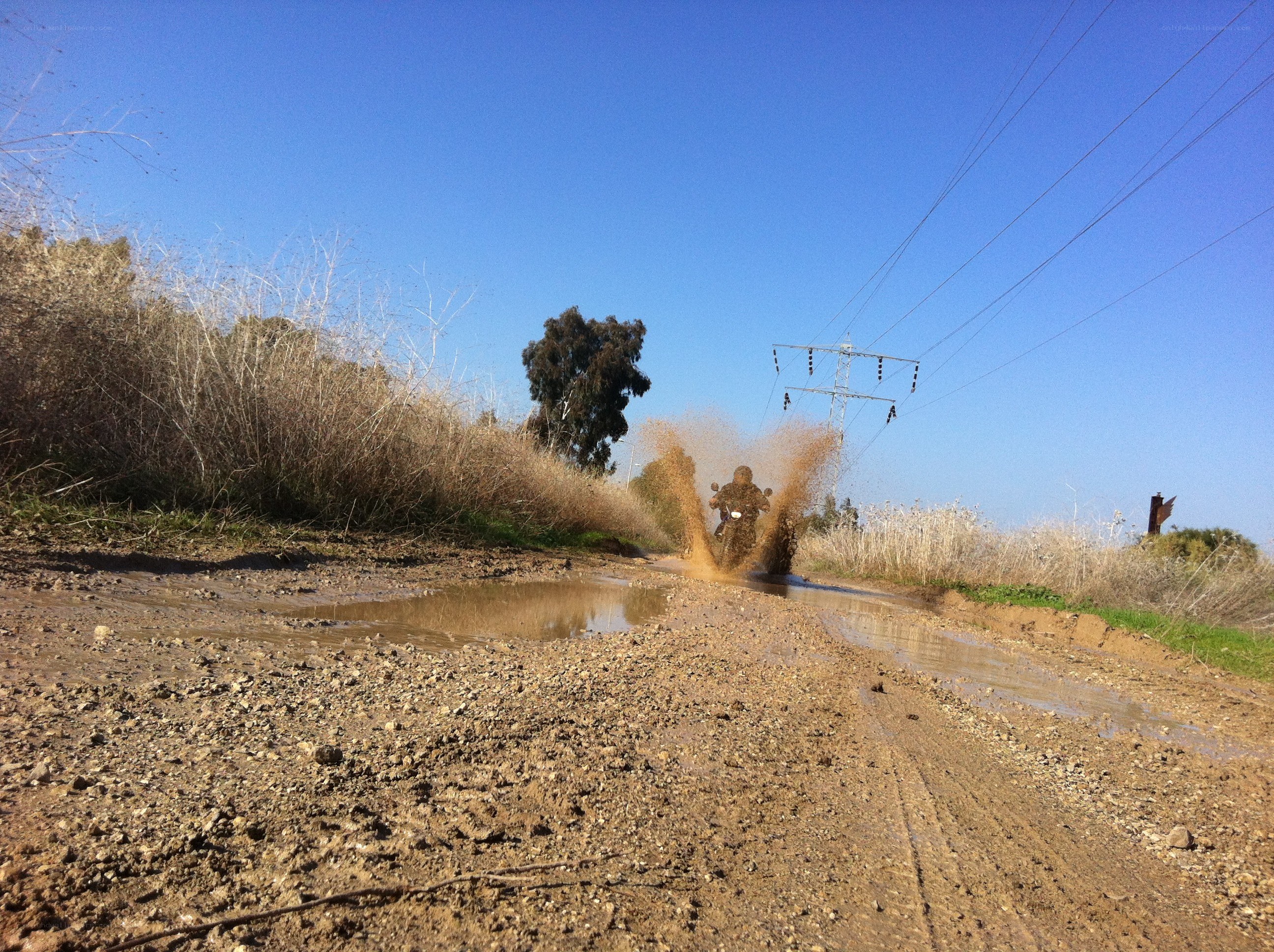 Motorcycle splashing through mud