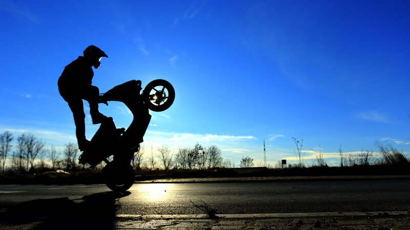 Motorcycle stunt at sunset