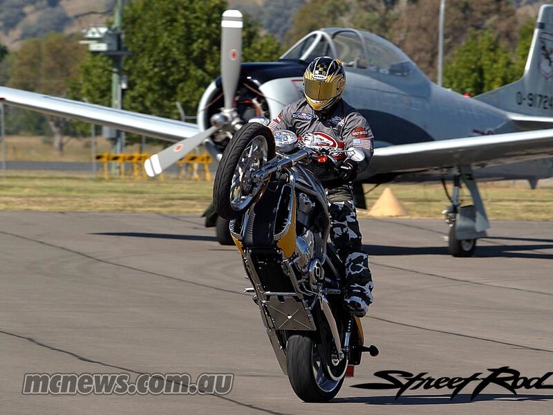 Motorcycle stunt with airplane in background