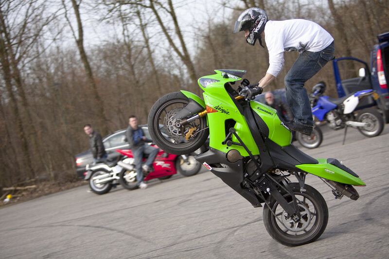 Motorcycle wheelie on green bike