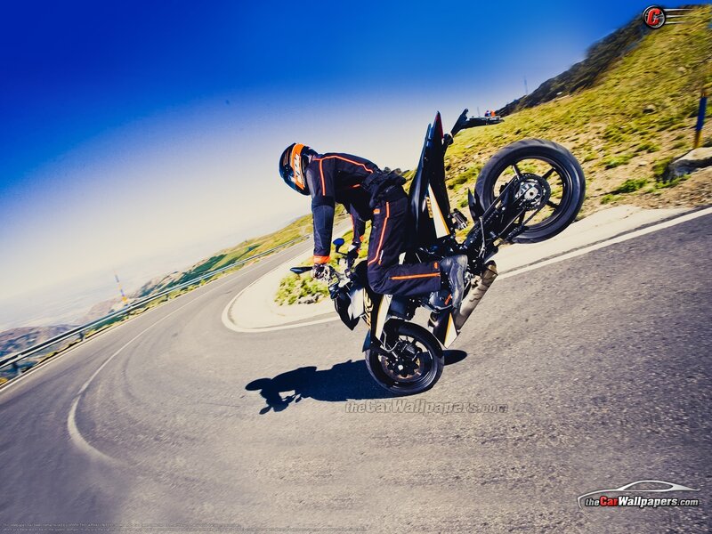 motorcycle wheelie on winding road