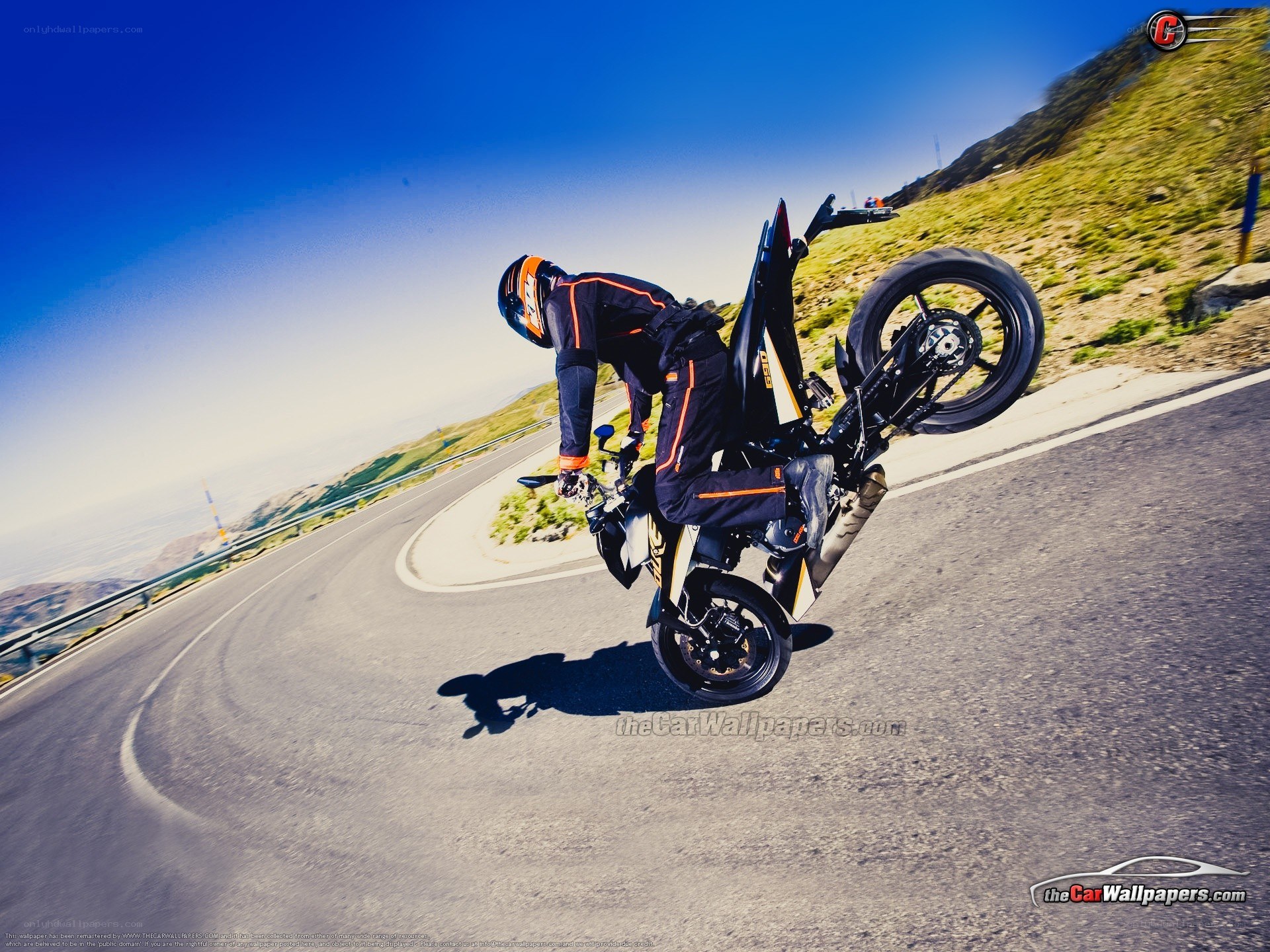 motorcycle wheelie on winding road