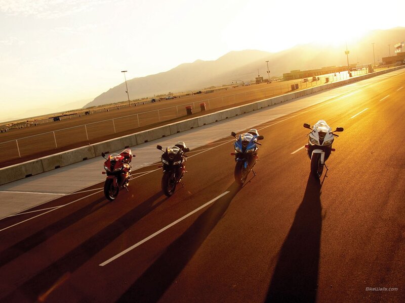Motorcycles on a racetrack at sunset