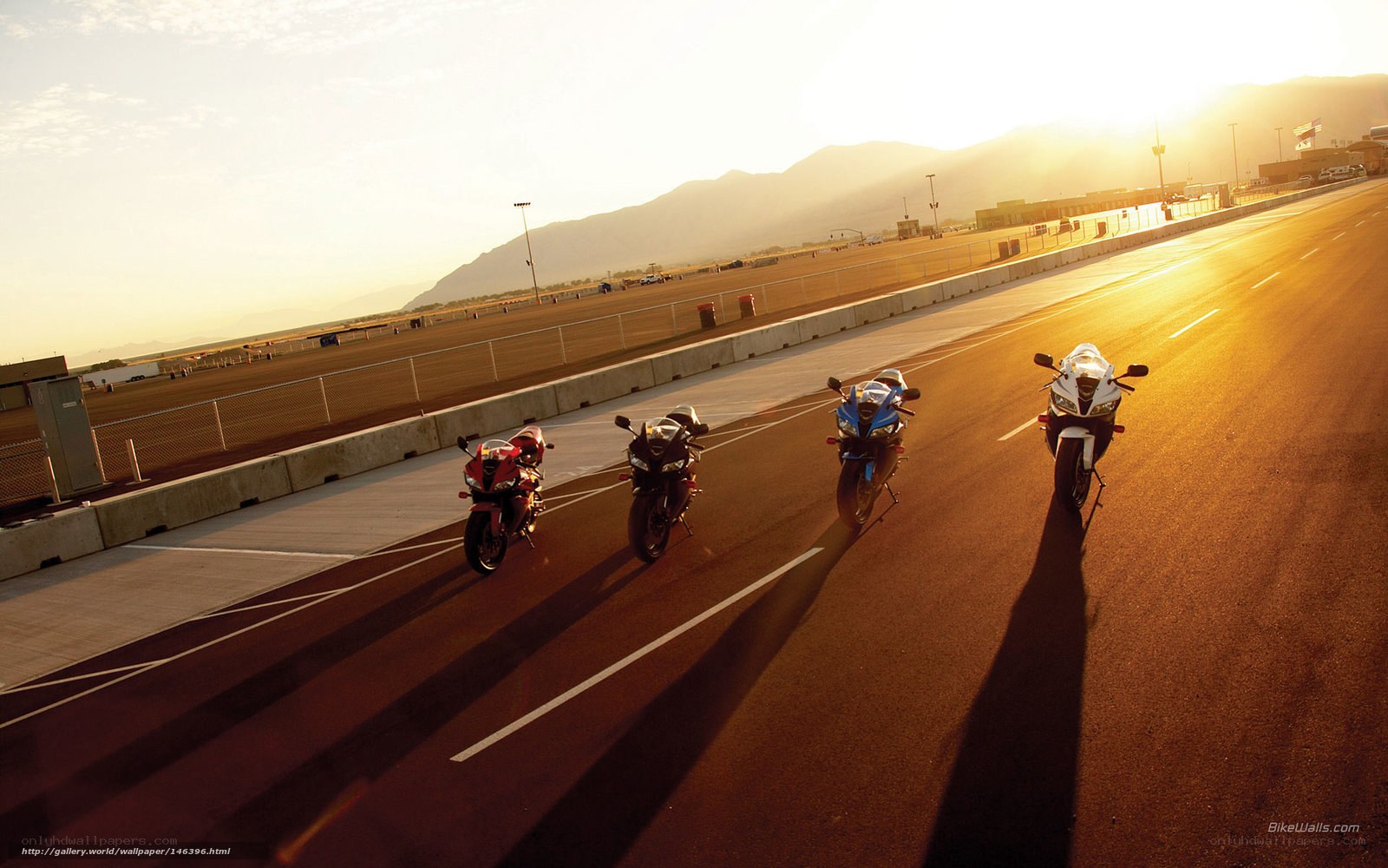motorcycles on racetrack at sunset