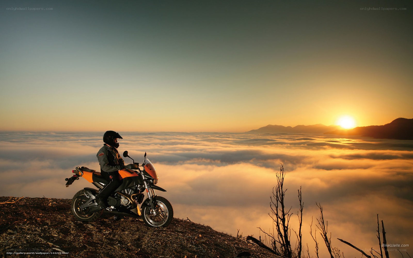 Motorcyclist at sunrise above clouds