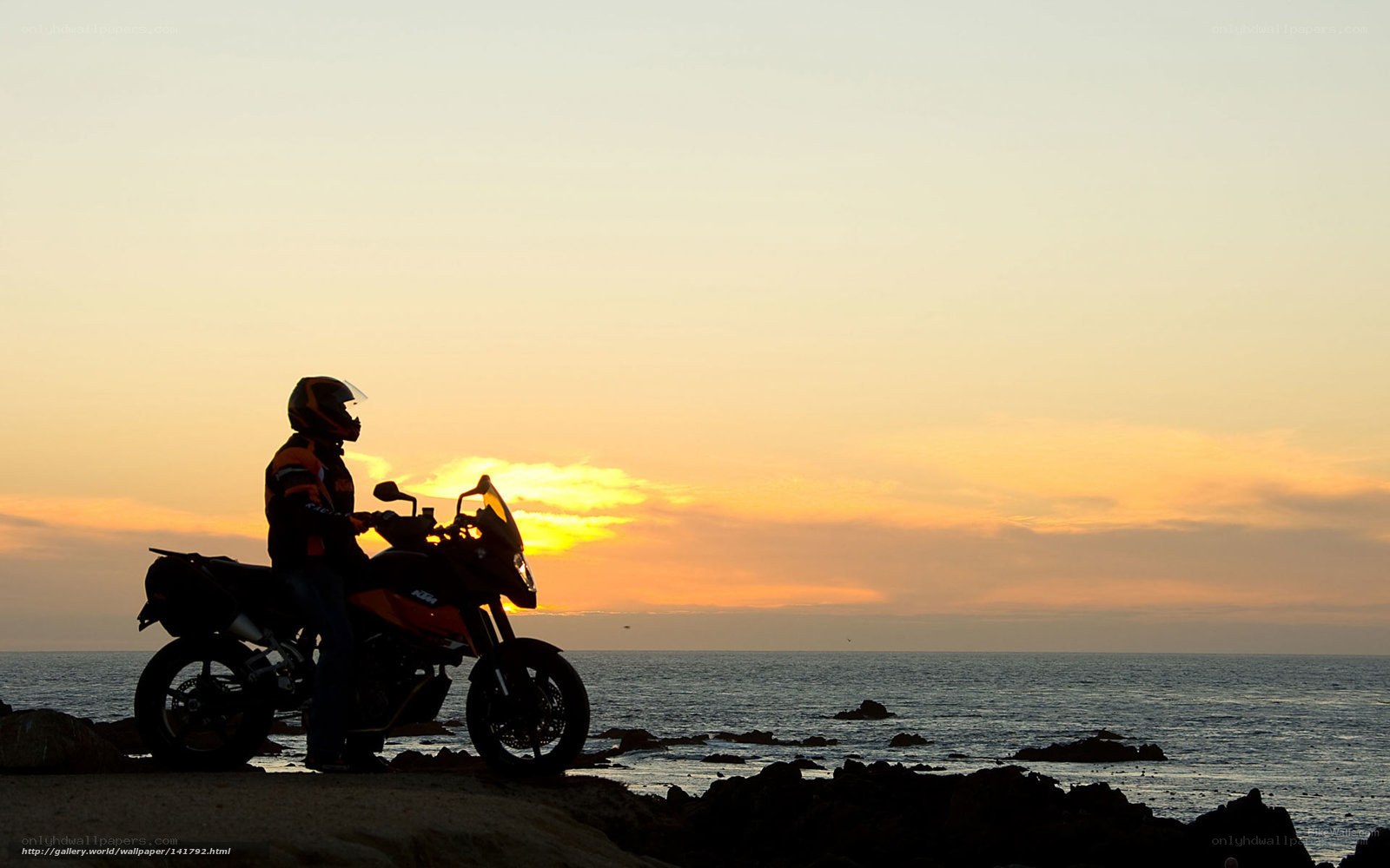 Motorcyclist at sunset by the sea
