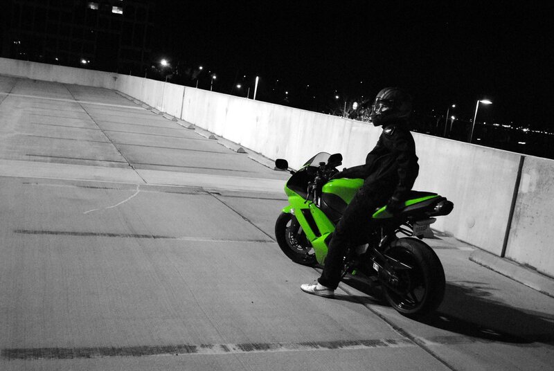 Motorcyclist on a green bike at night