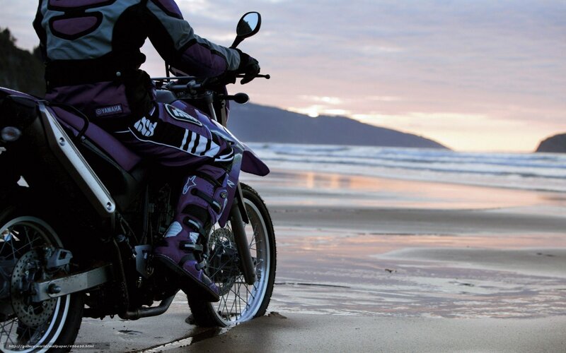 Motorcyclist on beach at sunset
