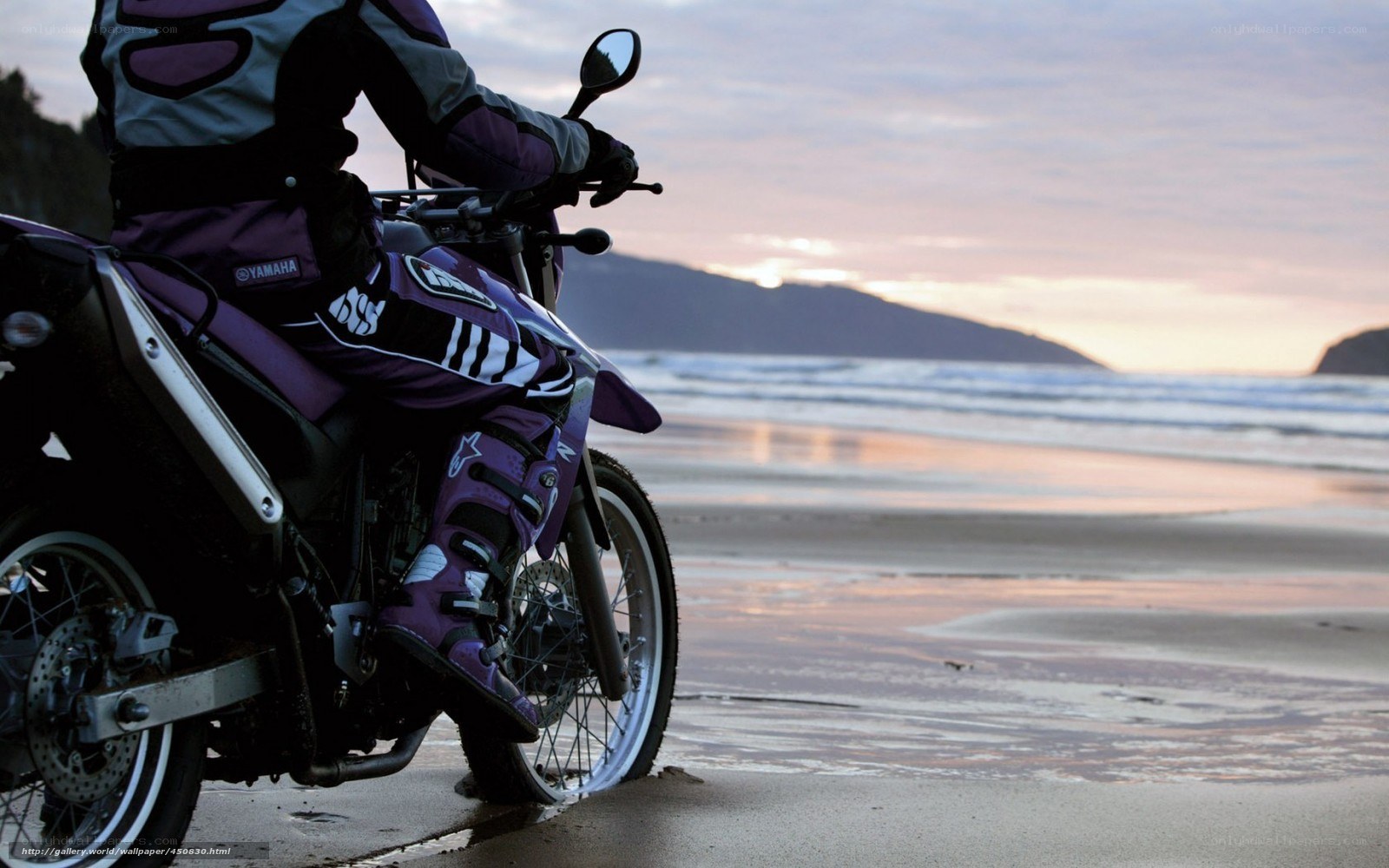 Motorcyclist on beach at sunset