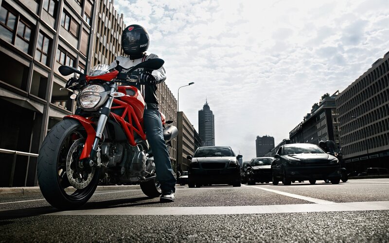 Motorcyclist on red bike in city