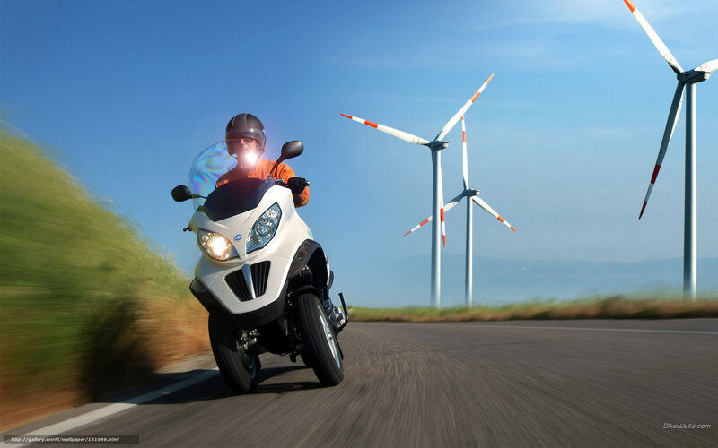 Motorcyclist on road with wind turbines