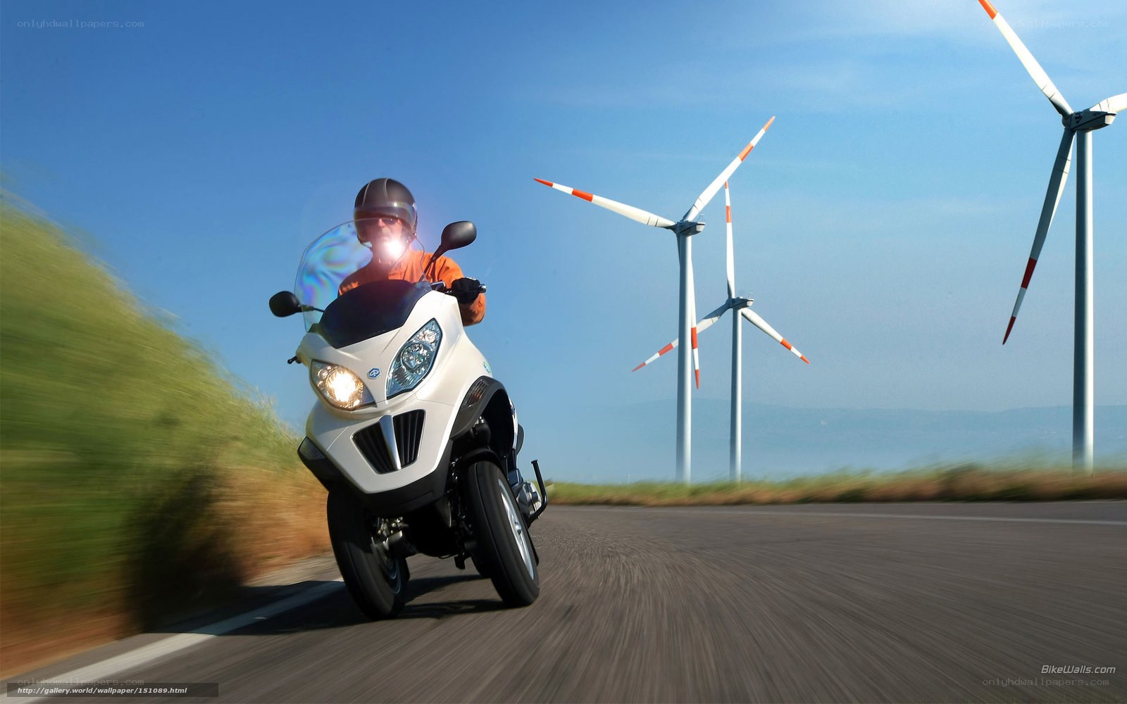 Motorcyclist on road with wind turbines