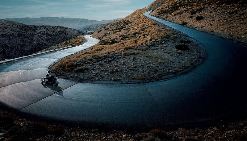 Motorcyclist on Winding Road — Gray, Dramatic, Afternoon, Photograph