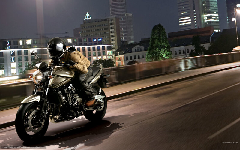 Motorcyclist riding at night in city