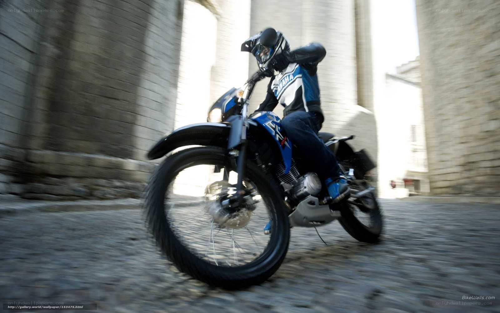 Motorcyclist riding on cobblestone street