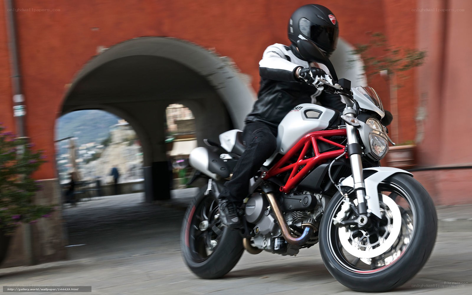 Motorcyclist riding through archway