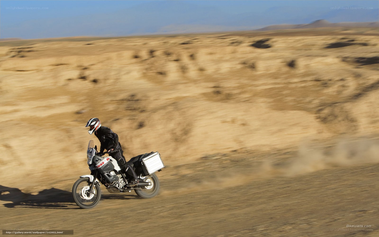 Motorcyclist riding through desert