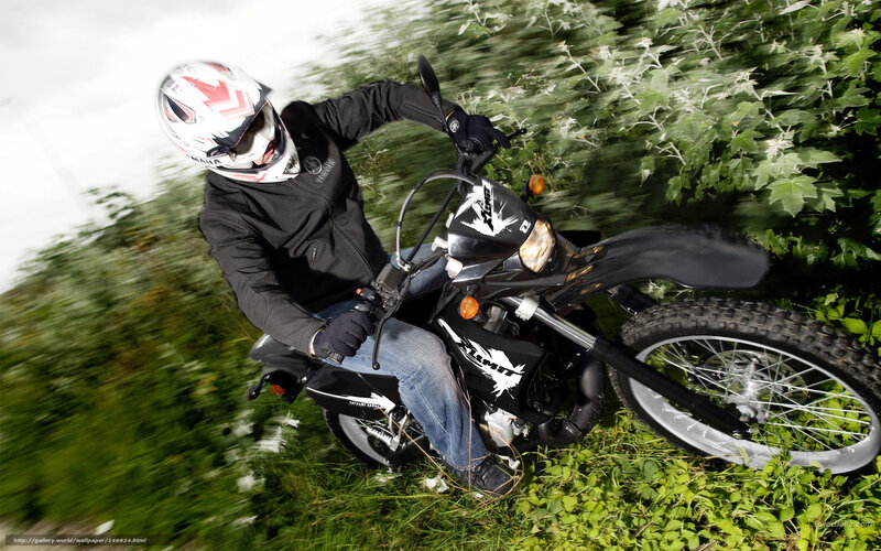 Motorcyclist riding through grass