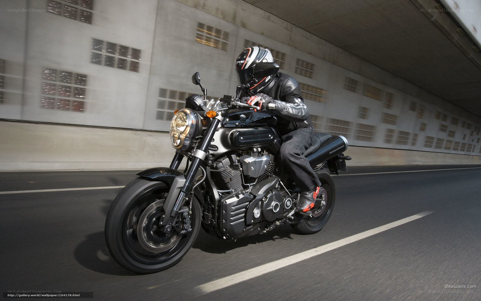 motorcyclist riding under tunnel