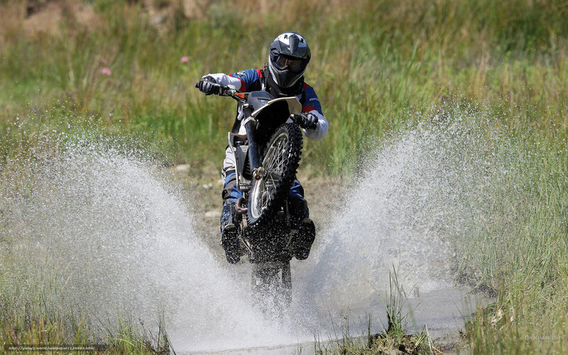Motorcyclist splashing through water