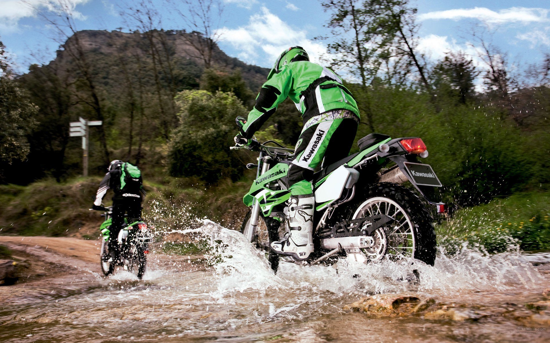 Motorcyclists riding through water