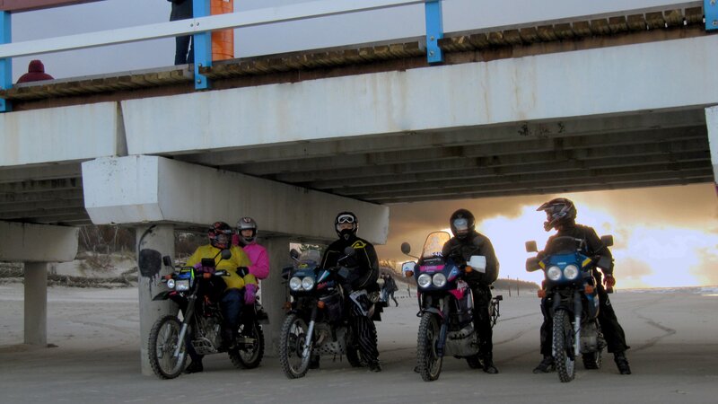 Motorcyclists under a bridge